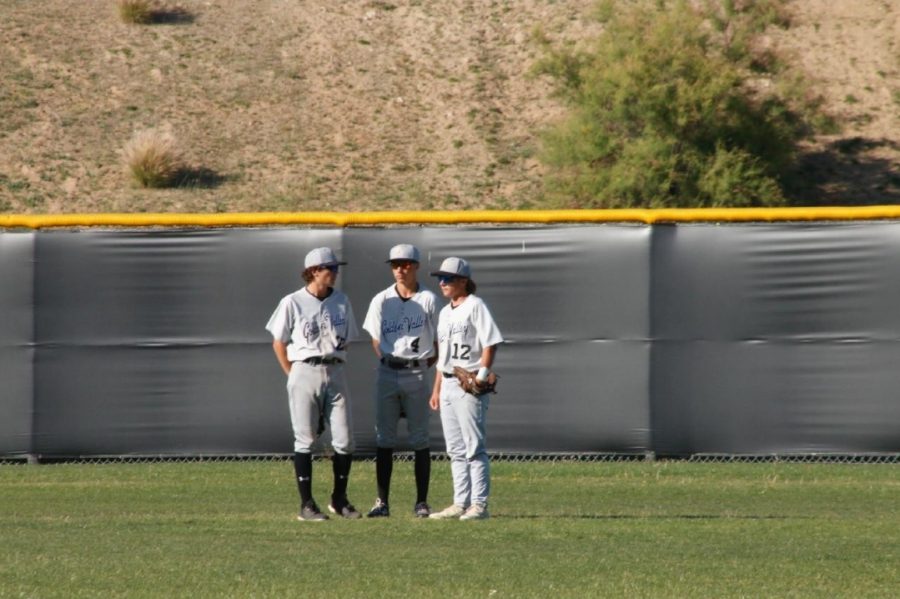 Outfielders Matthew Mahotz, Samuel Estrella, and Joey Scattaglia talk during a mound visit.