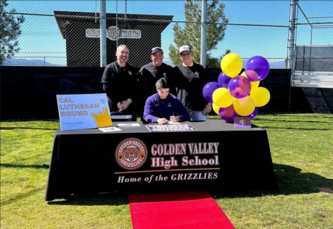 Wyatt (Center) signing his commitment papers on the baseball field surrounded by (left to right) Principal Sal Frias, Head Coach Adrien Rios, and his father and coach Mike Crosby.