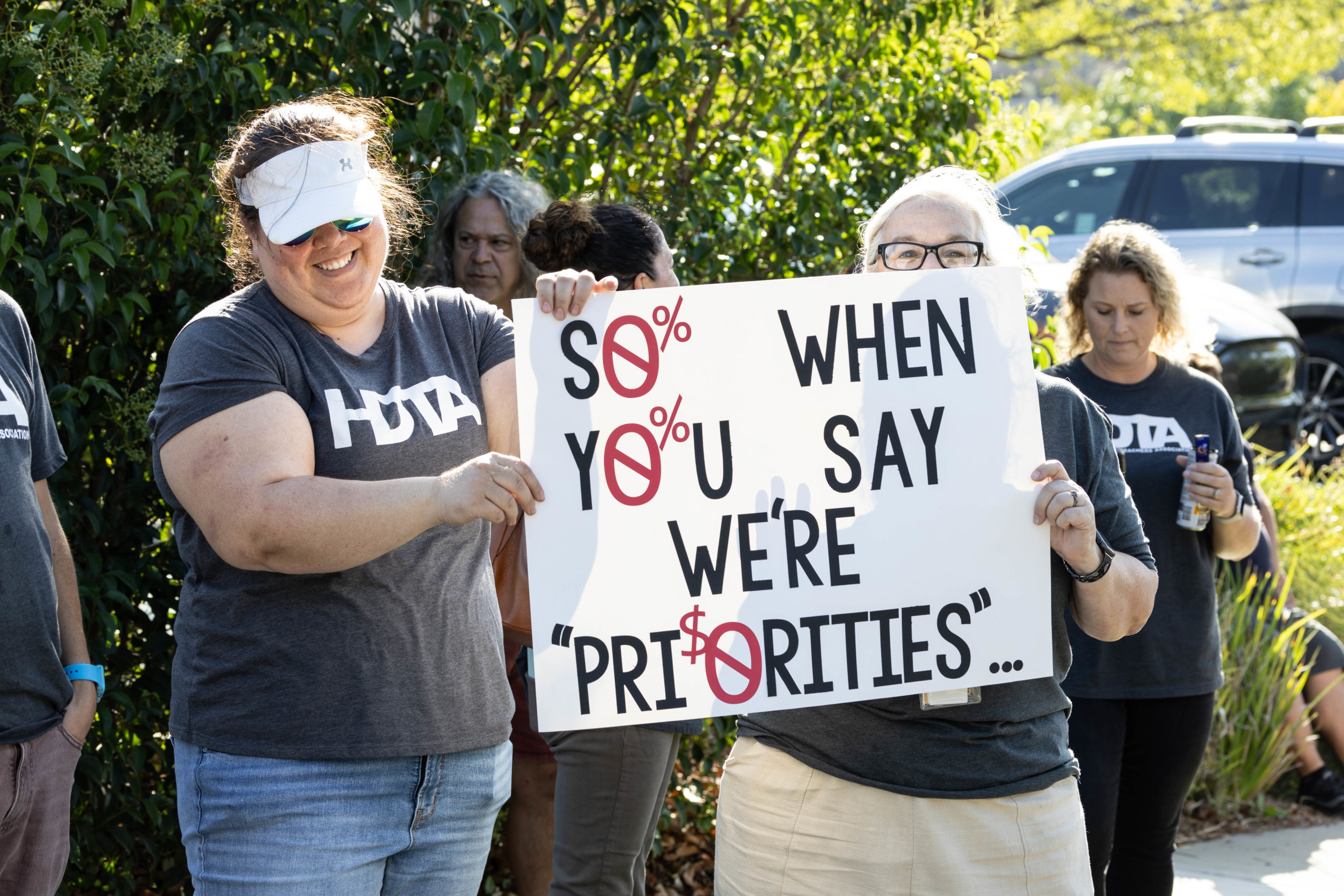 Sep 18, 2023- Teachers holding a sign in protest of wages.